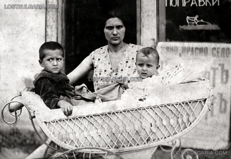 Майка с две деца в детска количка, пред обущарска работилница, София, 20-те години на ХХ век / снимка: lostbulgaria