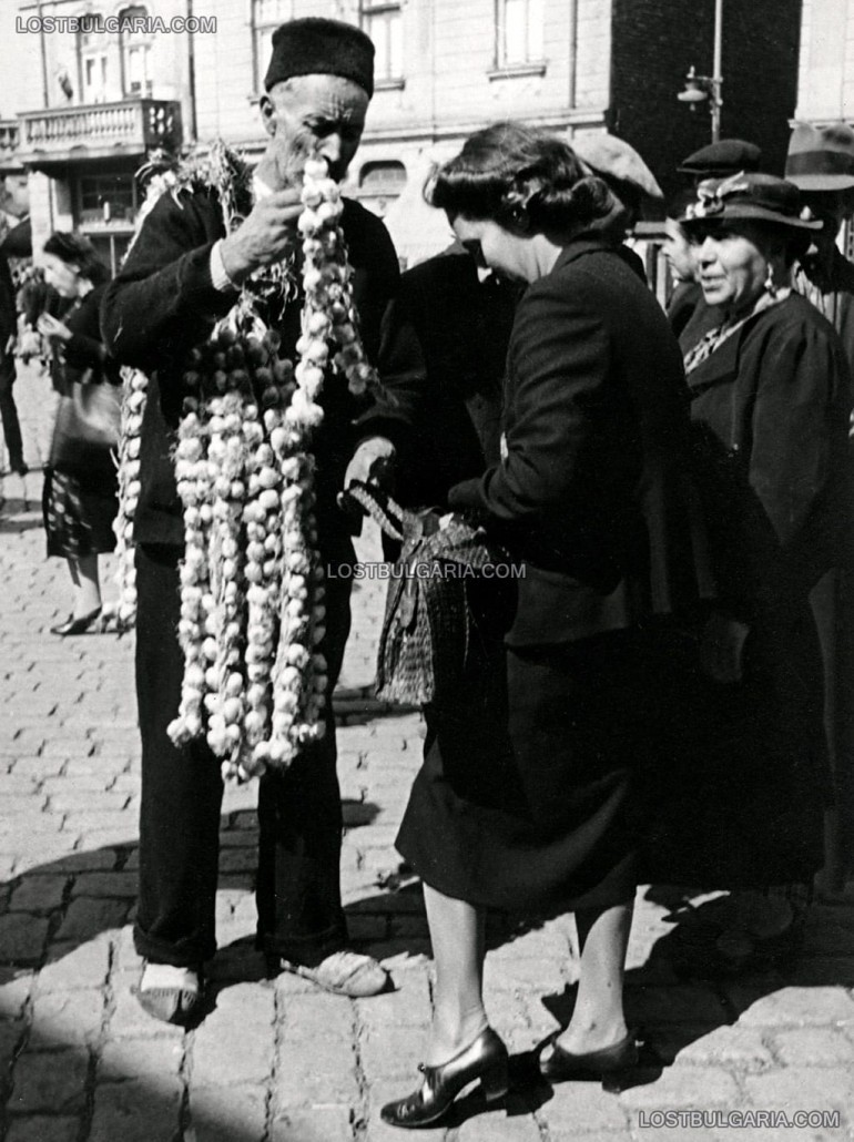 Градски облечена жена пазарува чесън от селяни от софийските села, Женския пазар, София, 30-те години на ХХ век / снимка: lostbulgaria.com