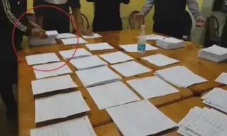 Член на комисията зачертава бюлетини от общия куп за общински